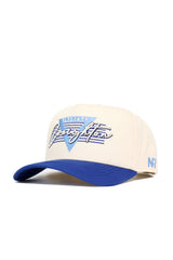The No Rivals Creighton Triangle Game Cap Hat is cream with a blue brim, embroidered Blue Jays Creighton text, a blue V on the front, and NR lettering on the side. This structured snapback is officially licensed for authentic style.