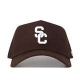 The USC Trojans Americano Hat is a brown baseball cap with white embroidered interlocking S and C on the front, featuring a structured fit for added style.