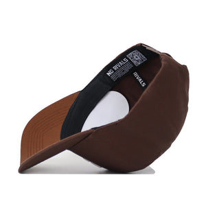 The USC Trojans Americano Hat is a brown snapback turned on its side to reveal a black sweatband with white NO RIVALS text and a QR code on the label. Made from high-quality cotton for a comfortable, structured fit.
