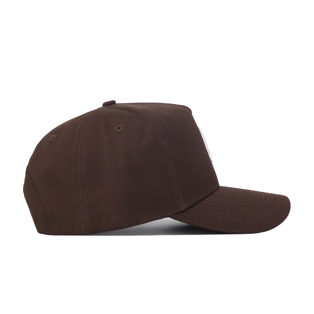 The UConn Americano Hat is displayed in a side view, featuring high-quality cotton, a curved brim, and top button. Its structured fit creates a classic look, and this side appears plain with no visible logos or decorations.