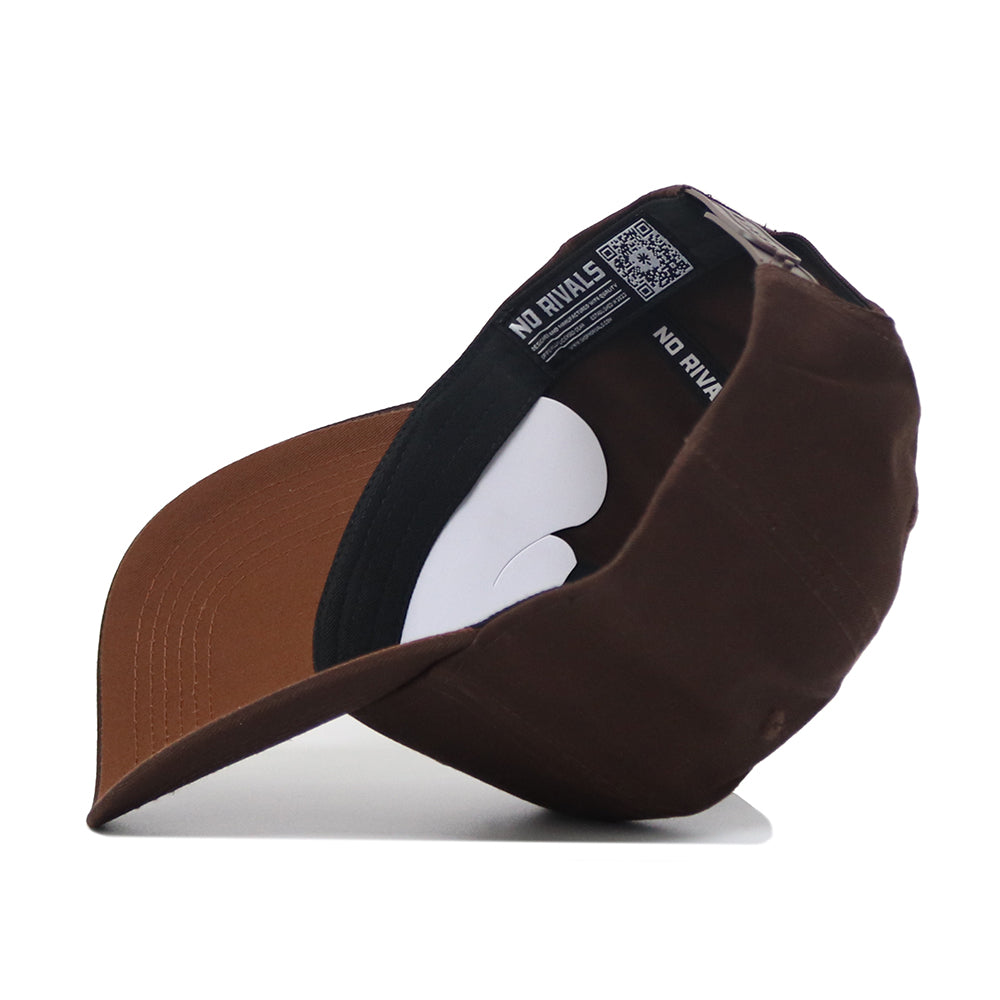 The UConn Americano Hat is a brown snapback shown from the side, resting on its brim with the interior visible. It features a black sweatband, white insert, and "NO RIVALS" printed on the inside band.