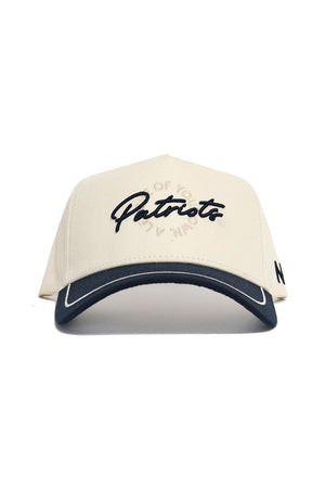 The No Rivals DBU Patriots ALOYO Hat is a cream snapback with "Patriots" in black script, a black visor with white trim, quality cotton structured fit, and a small black side detail.