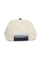The No Rivals DBU Patriots ALOYO Hat is a beige snapback with a structured fit, dark adjustable closure, and two small ventilation eyelets, shown from the back.