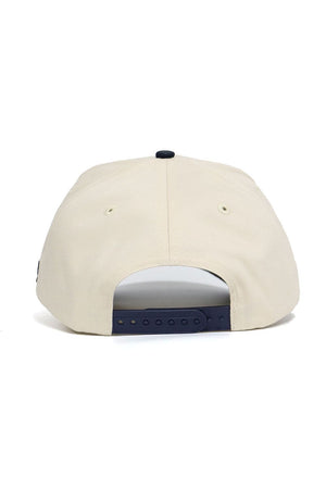The No Rivals DBU Patriots ALOYO Hat is a beige snapback with a structured fit, dark adjustable closure, and two small ventilation eyelets, shown from the back.