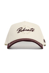 The Texas State Bobcats ALOYO Hat by No Rivals is a cream cotton cap with "Bobcats" embroidered in maroon on the front, a maroon accent on the brim, and subtle circular text around the logo. Officially licensed.