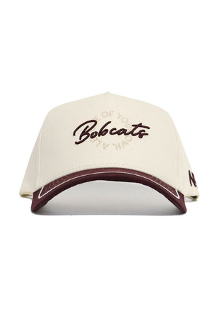 The Texas State Bobcats ALOYO Hat by No Rivals is a cream cotton cap with "Bobcats" embroidered in maroon on the front, a maroon accent on the brim, and subtle circular text around the logo. Officially licensed.