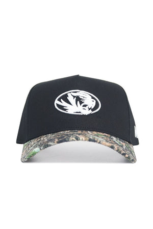 The No Rivals Mizzou Logo Camo Hat - Trailblazer Edition features a white embroidered tiger logo, camouflage brim, adjustable snap back, and is crafted from high-quality cotton for comfort.