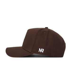 The NC State Americano Hat is a brown snapback, shown in profile with white "NR" embroidery above the ear, crafted from high-quality cotton and set against a white background.