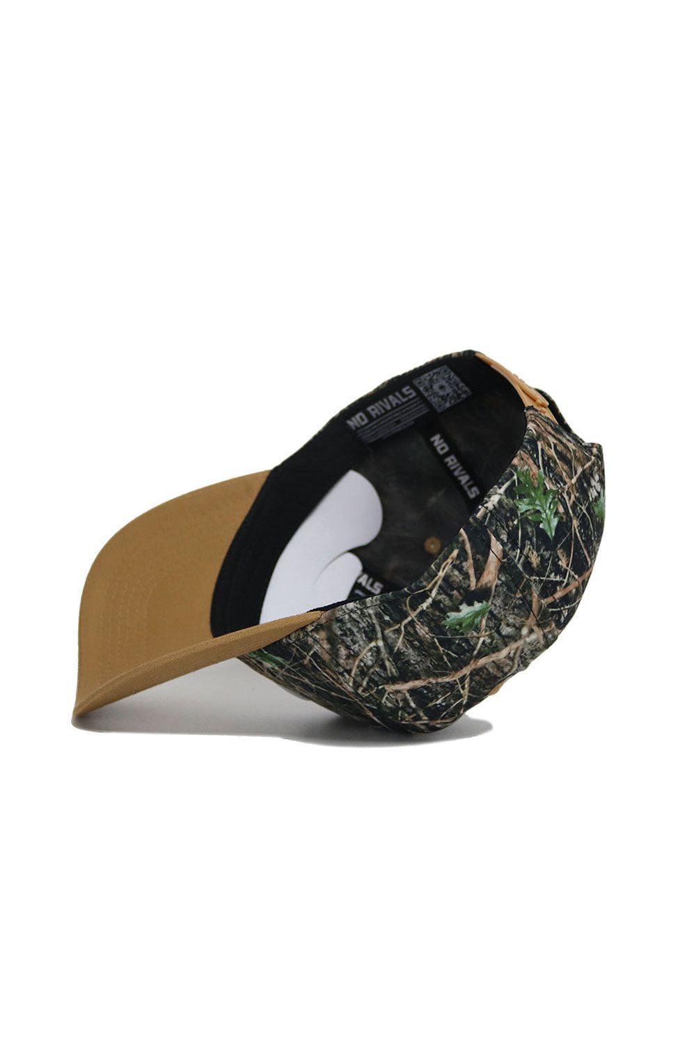 The Michigan State Camo Hat - Explorer Edition by No Rivals features a leafy woodland pattern, tan brim, snap back for perfect fit, and a black interior band labeled NO RIVALS. The high-quality cotton cap is shown upside down to display its details.