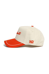 The SHSU Bearkats ALOYO Hat by No Rivals is a cream structured snapback with a red brim and accents, made from premium cotton. It features red NR initials on the side and red cursive embroidery on the front.