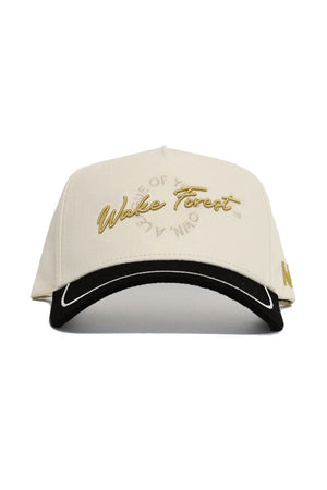 The Wake Forest ALOYO Hat by No Rivals is a cream cotton baseball cap with "Wake Forest" in gold embroidery, a black curved brim with white trim, and a snapback closure for a comfortable fit.