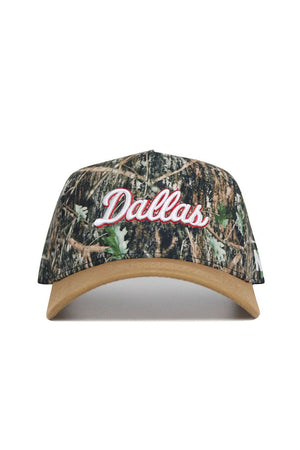 The Dallas Camo Hat - Explorer Edition by No Rivals features “Dallas” in white with a red outline on the front, a brown curved brim, and a snapback closure—all crafted from high-quality cotton with a camouflage pattern.