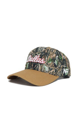 The Dallas Camo Hat - Explorer Edition by No Rivals features a camo crown, "Dallas" in white and red script, a solid tan brim, and NR stitched in white. Made from premium cotton for comfort and durability.