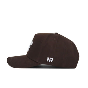 The Tulane Americano Hat is a brown baseball cap with a side view, featuring a small white NR logo embroidered near the back. Made from high-quality cotton, it has a curved brim, visible stitching, and a structured fit for lasting comfort.