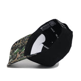 The Clemson Camo Hat - Trailblazer Edition by No Rivals features a black crown, a camouflage-patterned curved brim, an adjustable snap back strap, and displays the inside NO RIVALS label in an angled side view.