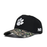 The No Rivals Clemson Camo Hat - Trailblazer Edition is a high-quality cotton black cap with a white paw print logo, camouflage visor, structured fit, and "NR" embroidered in white on the side.