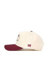 The Florida State Triangle Game Cap Hat is a white snapback with a structured fit, maroon brim and button, maroon NR embroidery on the side, an overlapping letter logo on the front, and made from high-quality cotton.