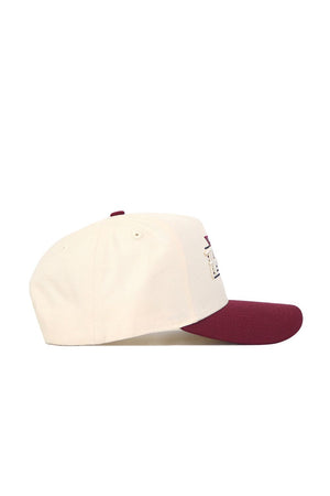 The Florida State Triangle Game Cap Hat is a cream-colored structured baseball cap with a maroon bill, embroidered front details, and ventilation holes, crafted from high-quality cotton and shown in profile.
