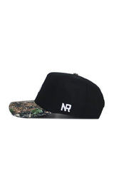 The Texas State Camo Hat - Trailblazer Edition by No Rivals is a black snapback cap with a camo brim, crafted from high-quality cotton and featuring white embroidered NR letters on the side, shown in side profile against a white background.
