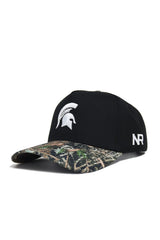 The Michigan State Camo Hat - Trailblazer Edition by No Rivals is a black snapback with a camo brim, featuring a white Spartan helmet front logo and NR on the side. Made from quality cotton for structured style and comfort.