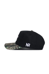 Side view of the No Rivals Kentucky Camo Hat - Trailblazer Edition: black snapback with a camouflage brim, white "NR" side embroidery, and crafted from high-quality cotton for comfort and durability.