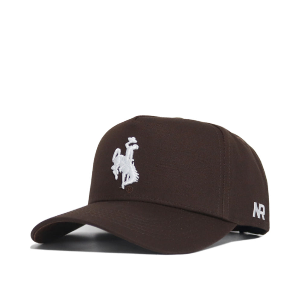 The Wyoming Americano Hat is a brown cotton baseball cap featuring a white embroidered cowboy on a bucking horse on the front and “AR” stitched in white on the side.