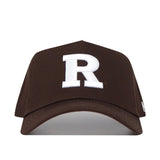The Rutgers Americano Hat (B2B) is a brown snapback crafted from high-quality cotton, featuring a large white embroidered letter "R" on the front for a structured fit.