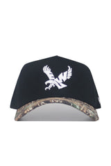 The No Rivals EWU Camo Hat - Trailblazer Edition is a black snapback crafted from premium cotton, with a structured fit, white eagle embroidery on the front, and a camo-patterned brim.