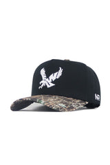 The No Rivals EWU Camo Hat - Trailblazer Edition is a structured fit snapback featuring a black crown, camo-patterned brim, white embroidered bird logo on the front, and NR initials on the side.