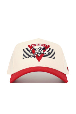 The No Rivals Utah Triangle Game Cap Hat is a cream baseball cap with a red brim, featuring "University of Utah" and a red triangle with black stripes on the front. This structured snapback offers comfort and official team style.