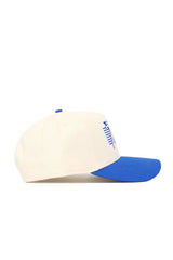 The No Rivals Tulsa Triangle Game Cap Hat features a cream color with a royal blue brim and side view. A blue embroidered graphic accents the front panel. This structured snapback hat is displayed against a white background.