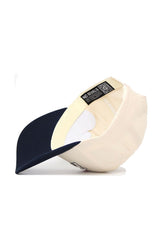 The Fresno State Triangle Game Cap Hat by No Rivals features a cream structured fit and dark blue brim. Shown upside down, it displays the NO RIVALS label inside and includes an adjustable back strap for comfort.