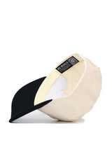 The Vanderbilt Triangle Game Cap Hat by No Rivals features a cream color, a structured fit, black underbrim, and an inside label with QR code and brand text. Modern style meets function in this snapback.