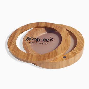 Product shot of the Boob-eez Bamboo Compact with Medium tint Headlight Hiders inside, close-up side shot showing the beautiful wood grain, magnetic closure, and translucent window to display the Headlight Hiders inside