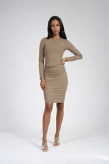 Woman wearing a beige long-sleeve dress on a white background