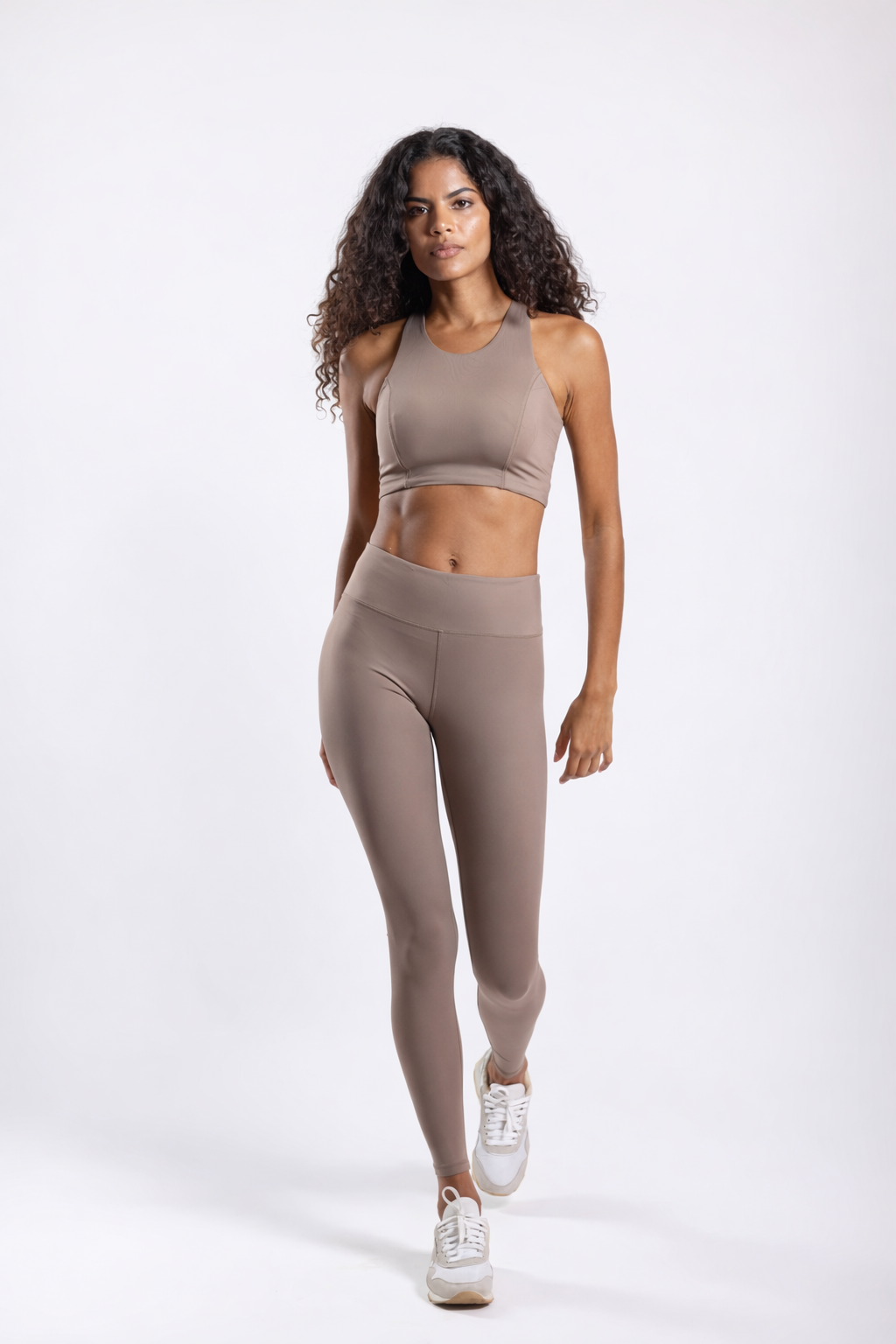Woman wearing a beige athletic outfit on a white background