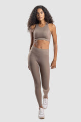 Woman wearing a beige athletic outfit on a white background