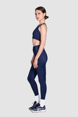 Woman wearing a navy blue athletic outfit on a white background