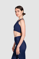Woman wearing a navy blue athletic outfit on a white background