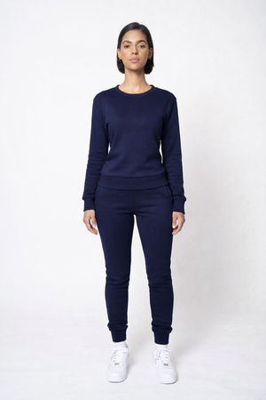 Person wearing a navy blue outfit with white sneakers on a white background