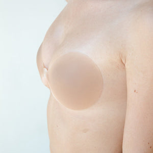 Product shot Medium tint Silicone Stick-on Bra size C-cup on light-skinned model, close-up side shot of the Silicone Stick-on Bra showing the skin tint matches the model perfectly and the razor thin edges creating a seamless look