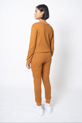 Back view of model wearing a mustard yellow outfit on a white background