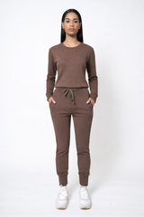 Woman wearing a brown tracksuit on a white background