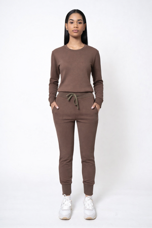 Woman wearing a brown tracksuit on a white background
