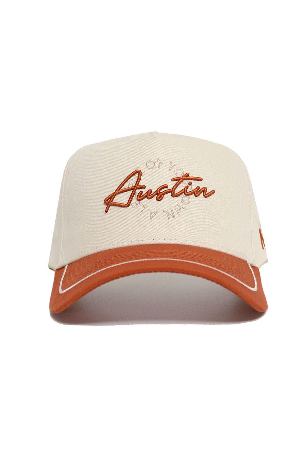 The No Rivals Austin ALOYO Hat features a beige snapback design with a rust brim and "Austin" in orange script, faint circular text, and is made from high-quality cotton for structure and comfort.