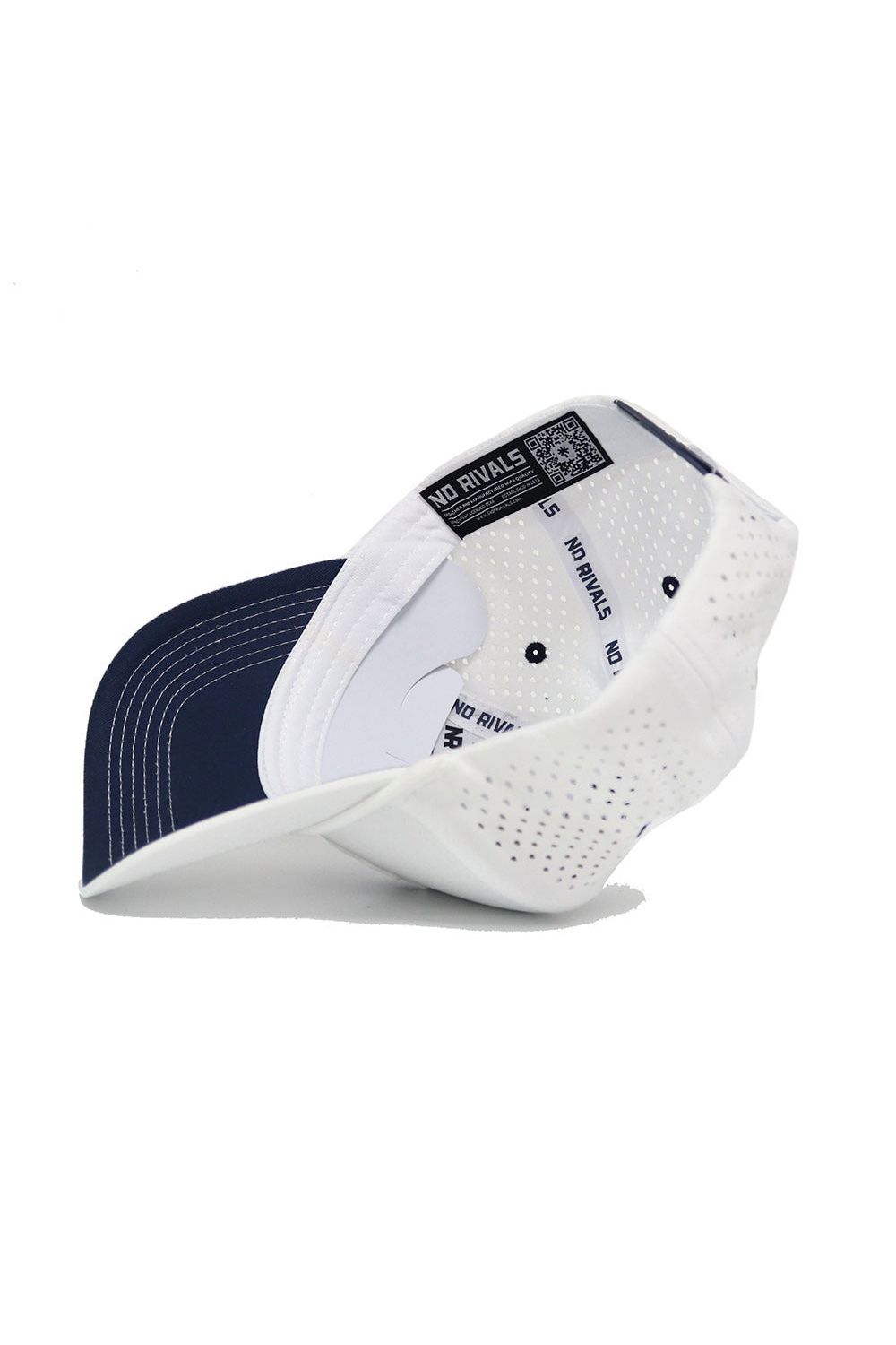 The image shows the inside of the Ole Miss Gameday Hat by No Rivals, featuring a white and navy design, "NO RIVALS" text on the inner band, ventilation holes, and a snapback closure for an adjustable fit.