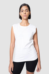 Woman wearing a white sleeveless top and black shorts on a light gray background