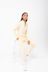 Person wearing a light yellow tracksuit on a white background