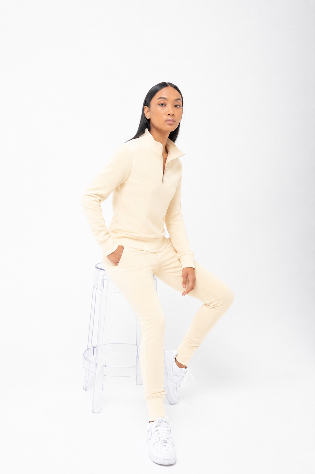 Person wearing a light yellow tracksuit on a white background