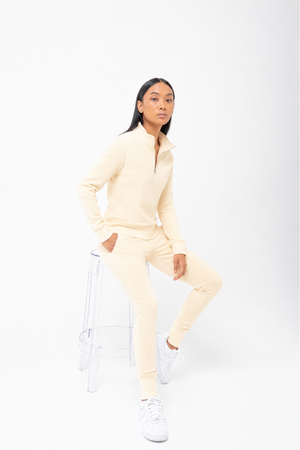 Person wearing a light yellow tracksuit on a white background